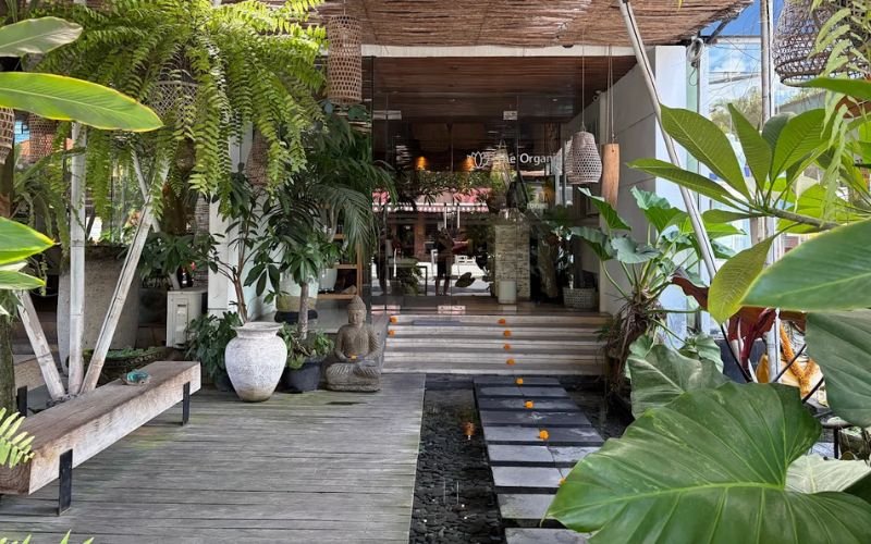steps leading to the entry way of a Balinese massage spa surrounded by lush greenery