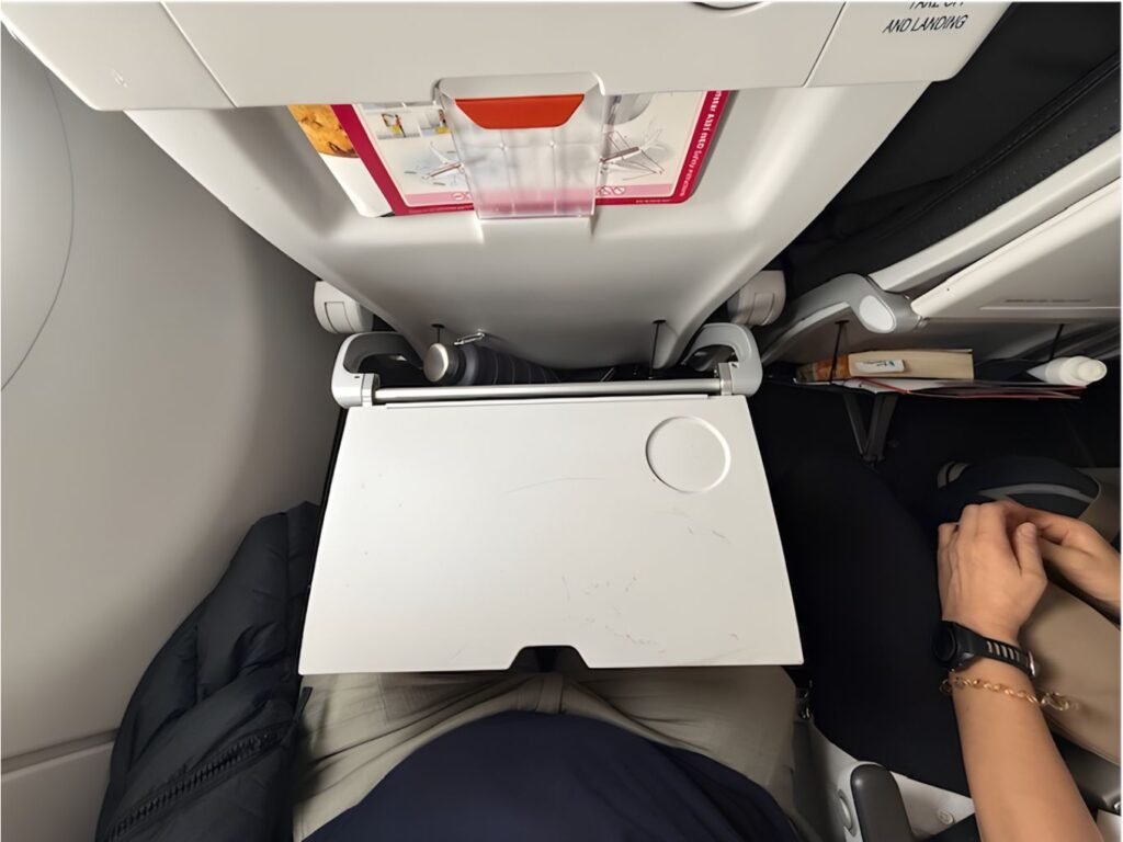 looking down from above onto an empty grey small aeroplane tray table