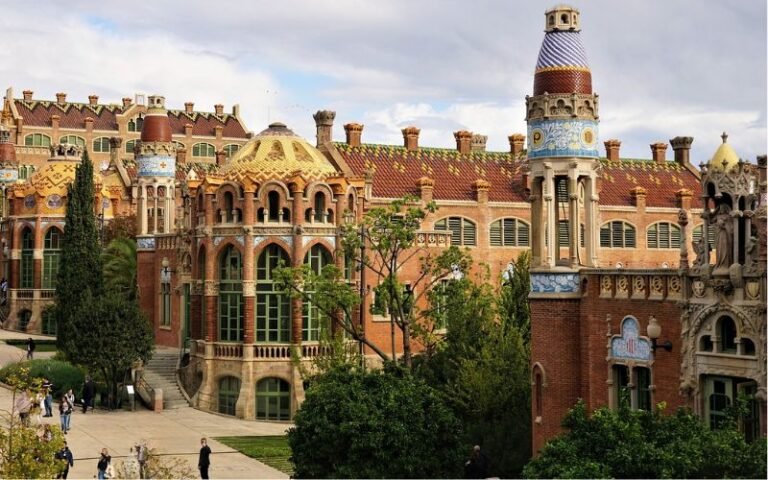 Impressive historical buildingv view taken from above featuring stain glass windows, arch entryways and expansive garden