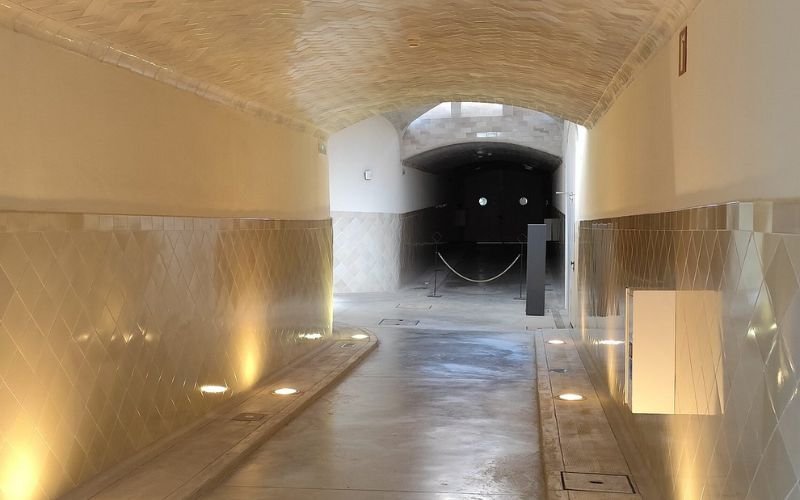 natural tone lino flooring with tunnel tiled walls across the ceiling