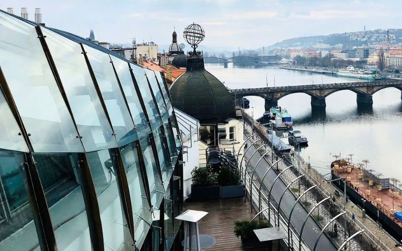 Expansive views from a rooftop overlooking wide river with bridges in the foreground