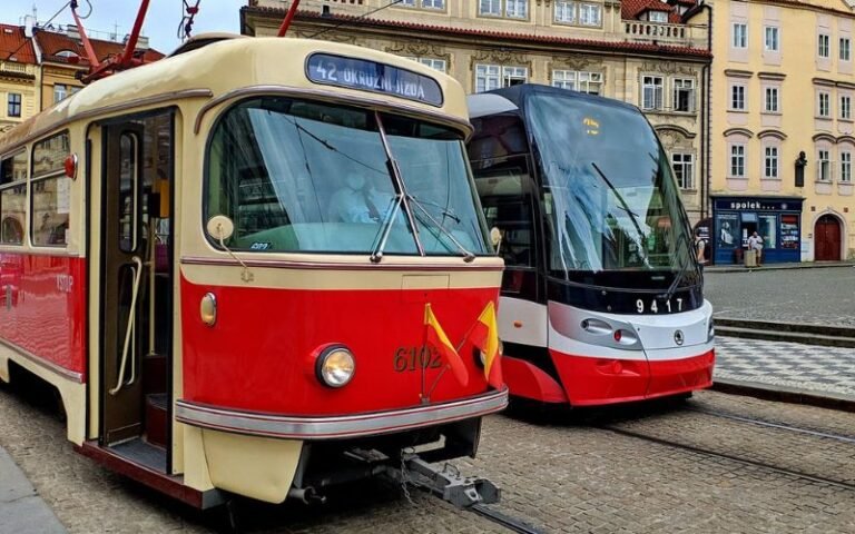 red and black trams with historic buildings in the background